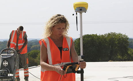 Eine Frau nimmt GPS-Messungen auf einer Baustelle vor